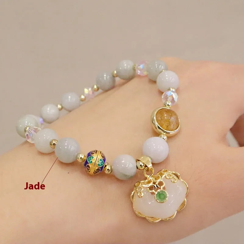 Geometric ethnic style jade bracelet for women with metal charm decoration in gray or strawberry quartz.