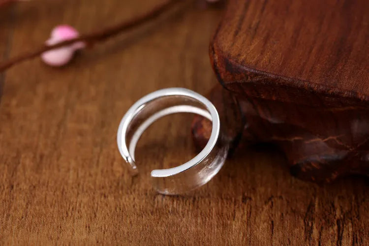 Geometric open sterling silver ring with frosted finish and adjustable gap.