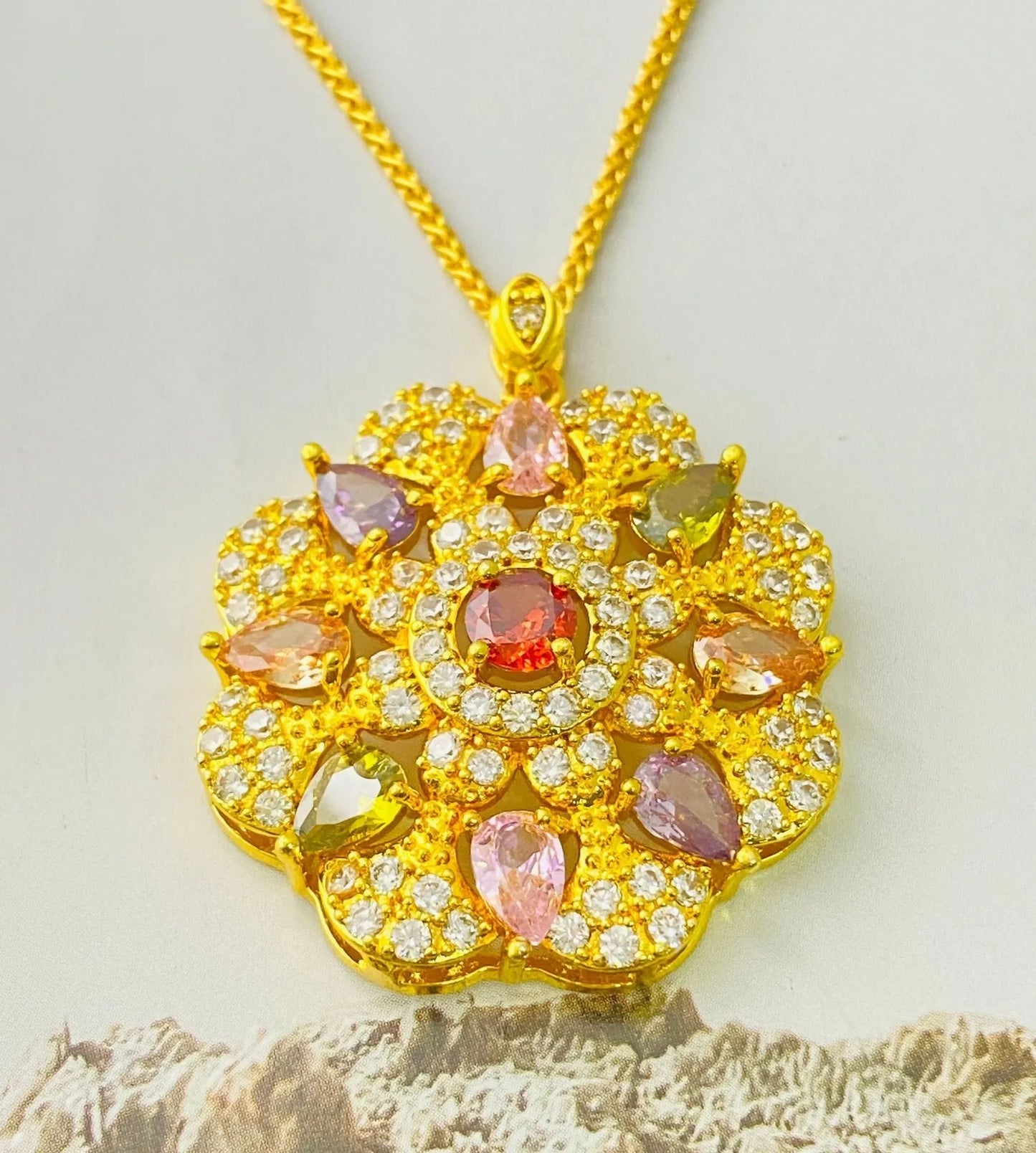Close-up of a women's gold-coloured flower pendant necklace with a bright zircon stone centre.