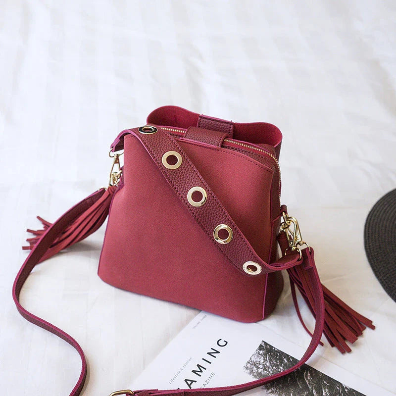 A stylish frosted tassel bucket bag with interior pockets and a versatile shoulder strap design