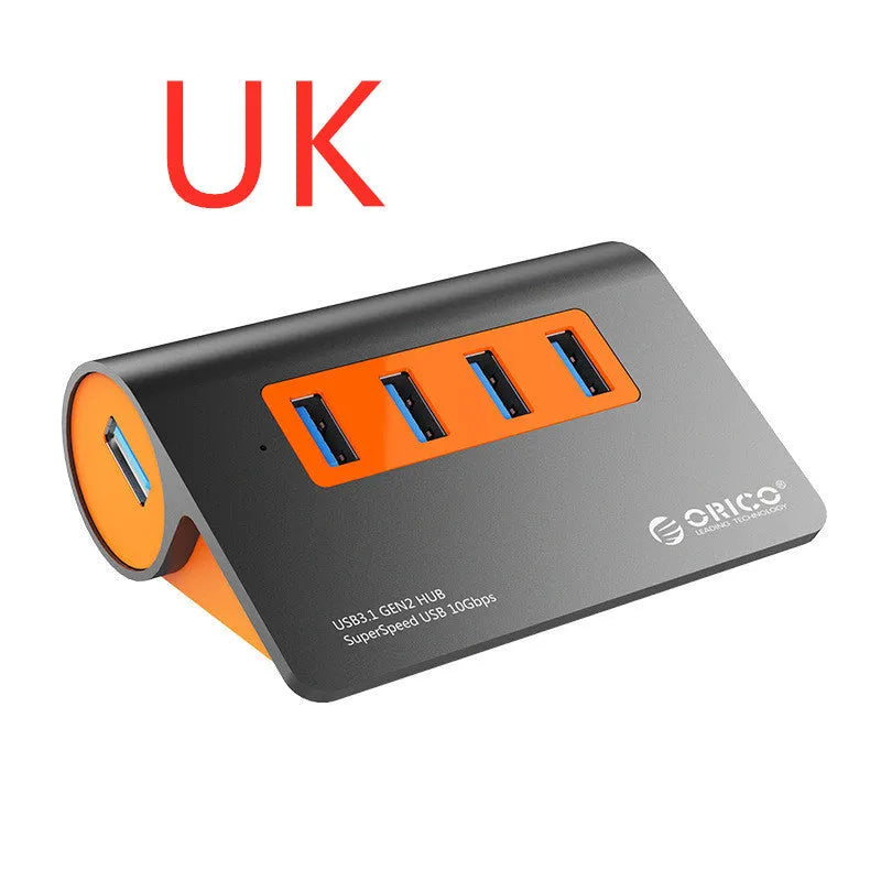 Dark grey aluminium USB-C laptop docking station with orange accents, showing USB ports, HDMI, and card readers.