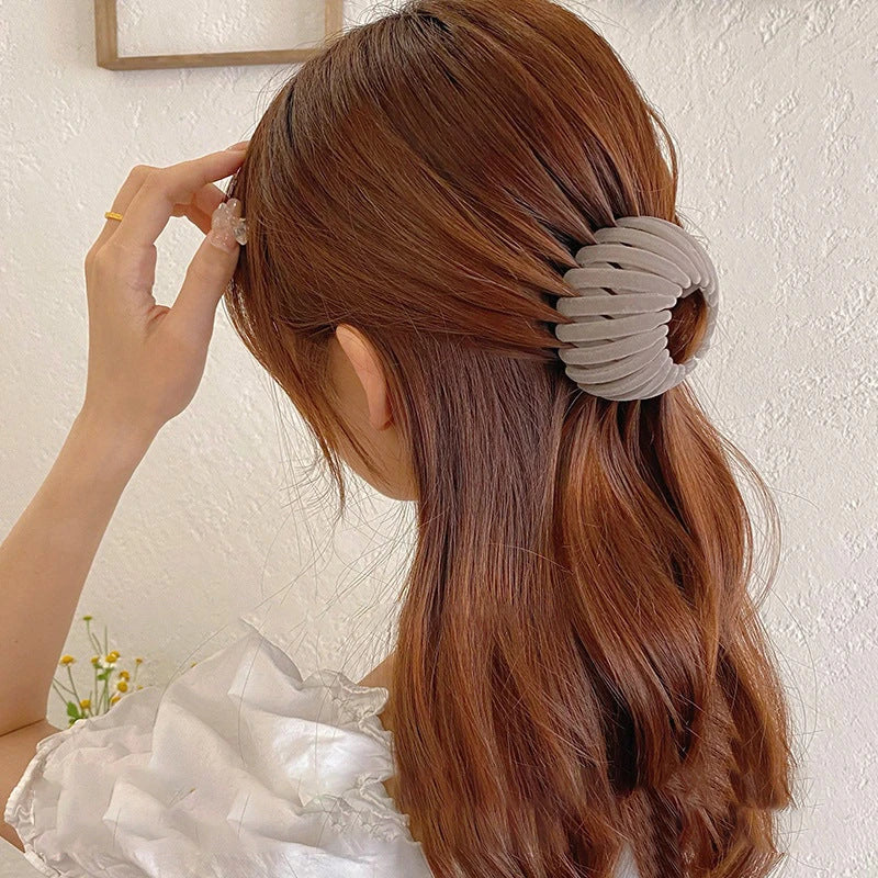 Adjustable ponytail hair accessory with flexible teeth, available in various colors, designed for easy, natural-looking hairstyles