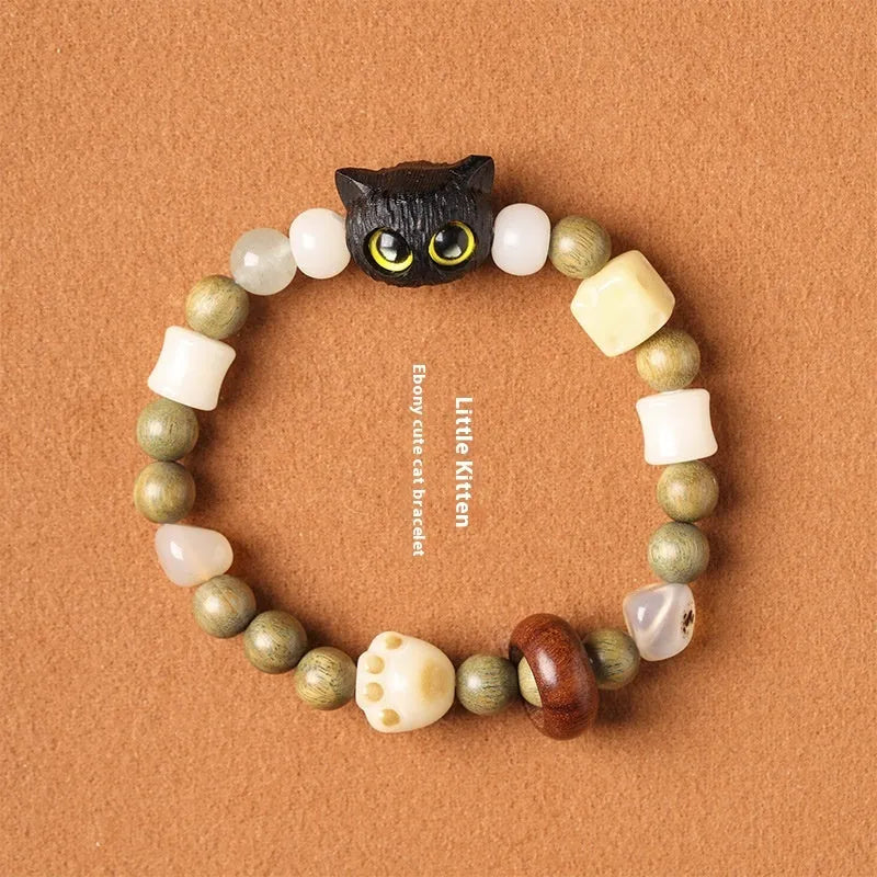 Hand-woven multi-treasure bracelet with jade, bodhi and ebony wood beads and a cartoon cat's paw charm.