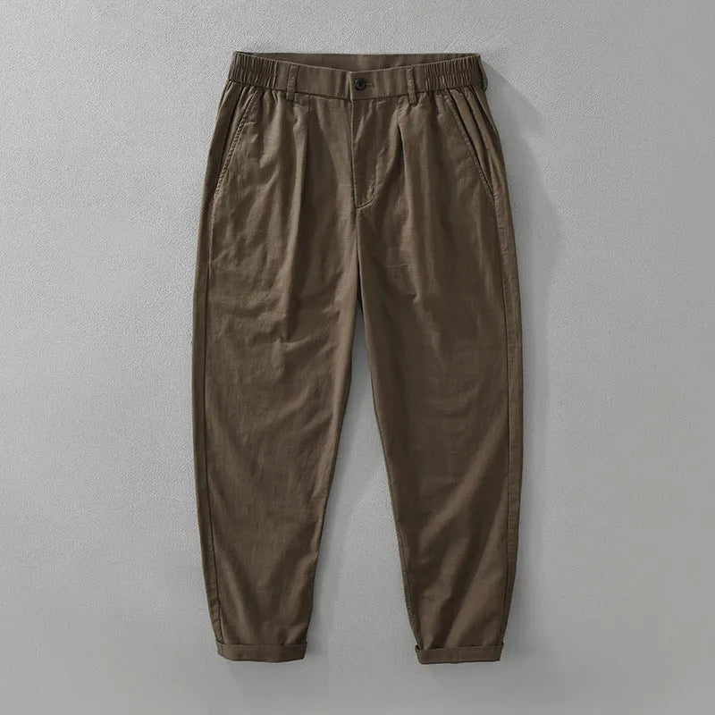 Man wearing loose beige straight-leg cotton linen trousers in a casual setting