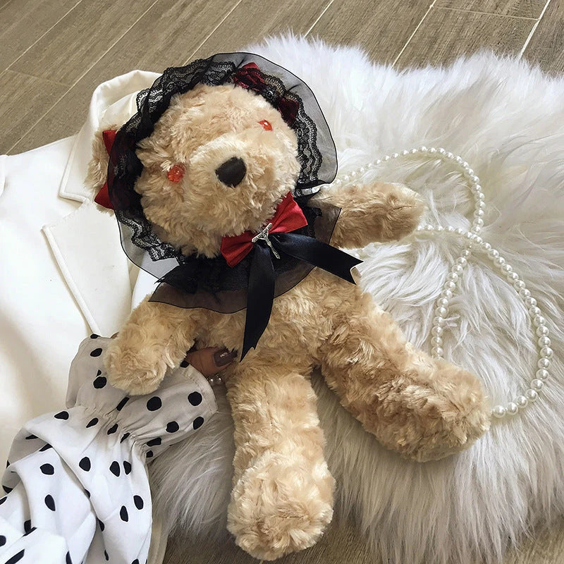 A plush teddy bear crossbody messenger bag with an adjustable shoulder strap and a zippered interior pocket for convenient storage.