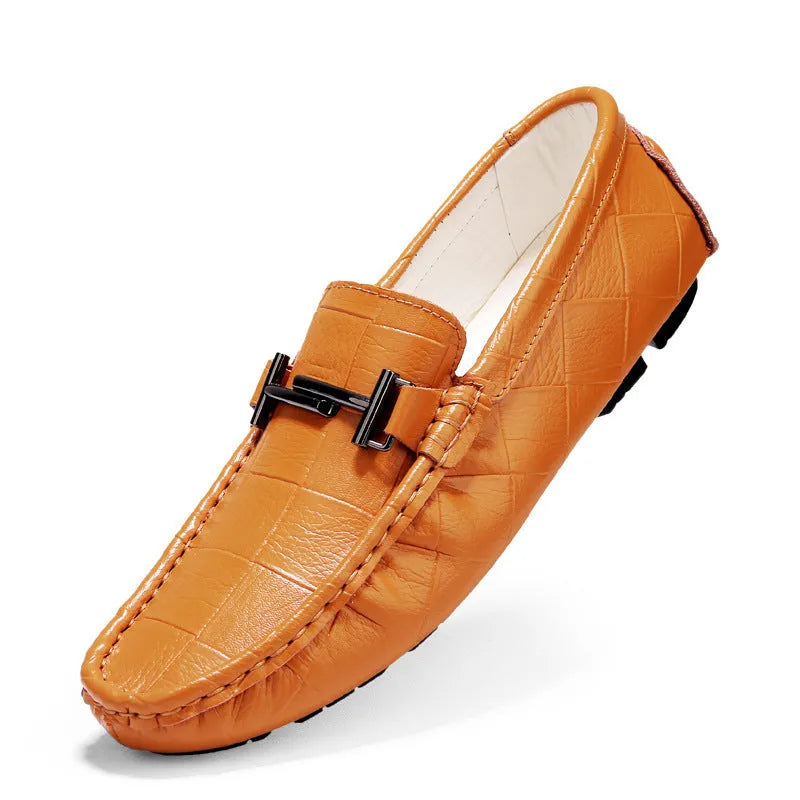 Men's brown leather casual shoes with a belt buckle on the upper, shown on a wooden surface.