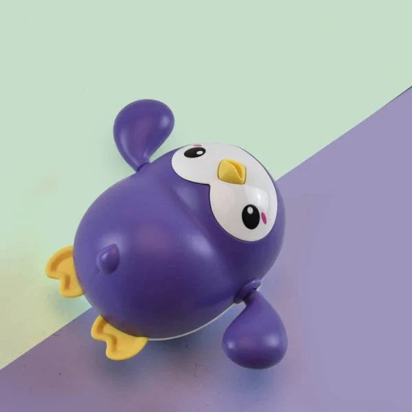 Colorful wind-up penguin bath toy swimming in the water, providing engaging water play for toddlers and young children.