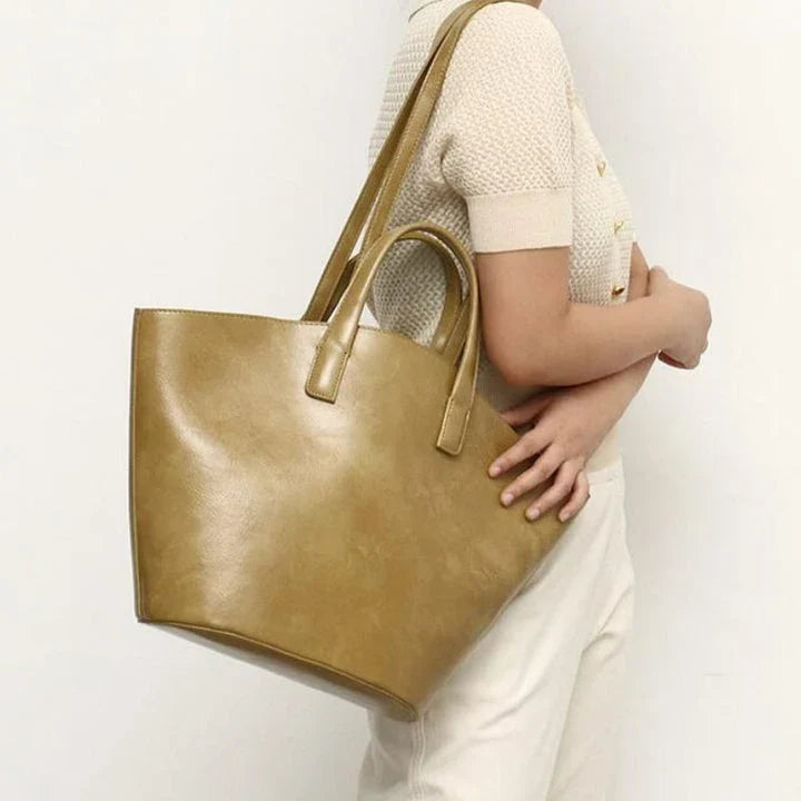 Elegant vegan leather tote bag with a unique bucket shape, versatile carrying options, and a secure zip liner for all your daily essentials.