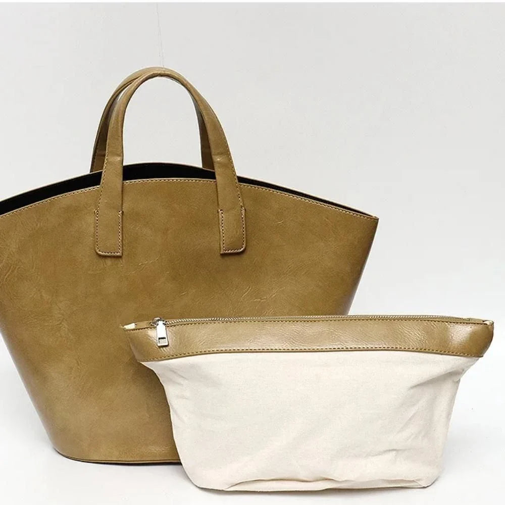 Elegant vegan leather tote bag with a unique bucket shape, versatile carrying options, and a secure zip liner for all your daily essentials.