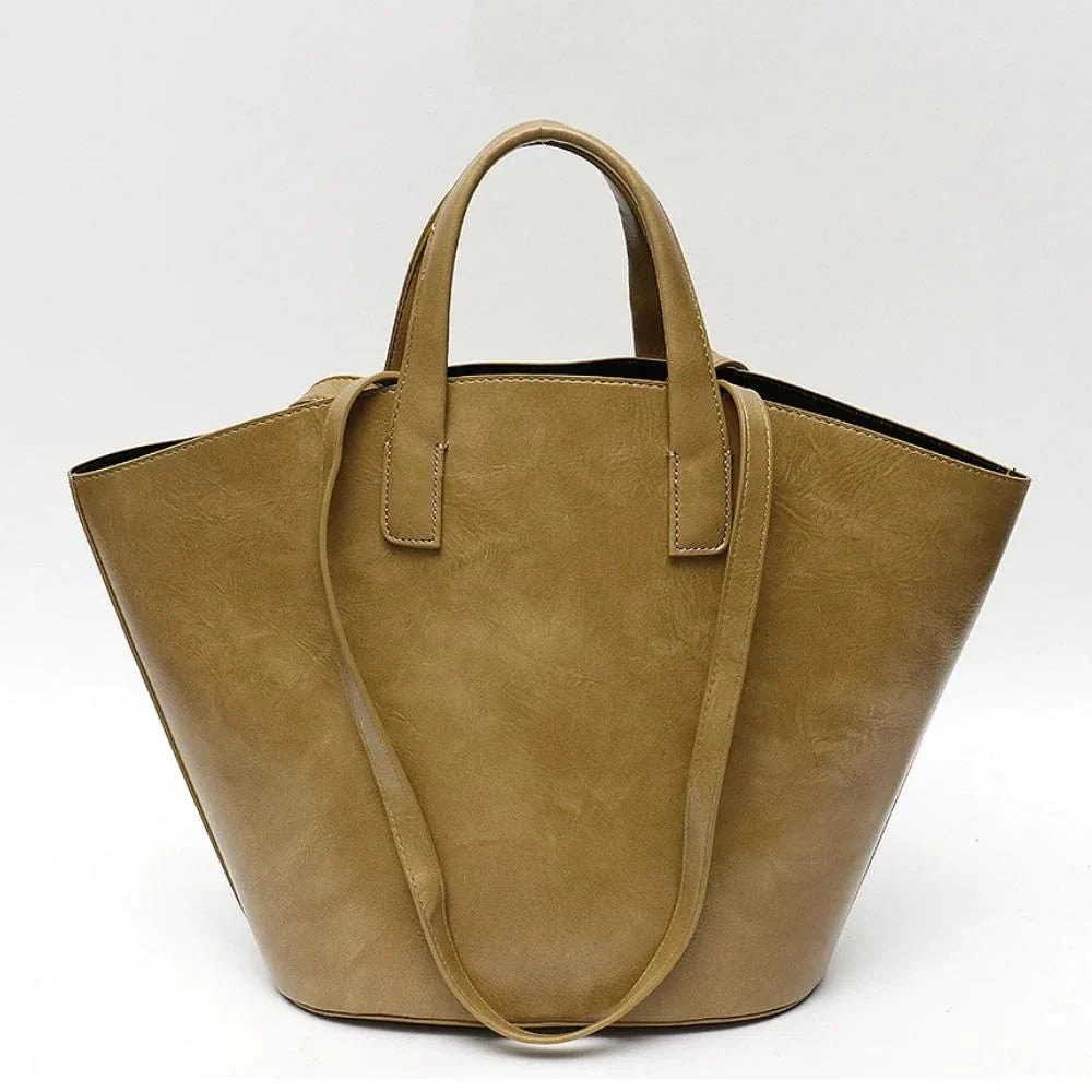 Elegant vegan leather tote bag with a unique bucket shape, versatile carrying options, and a secure zip liner for all your daily essentials.