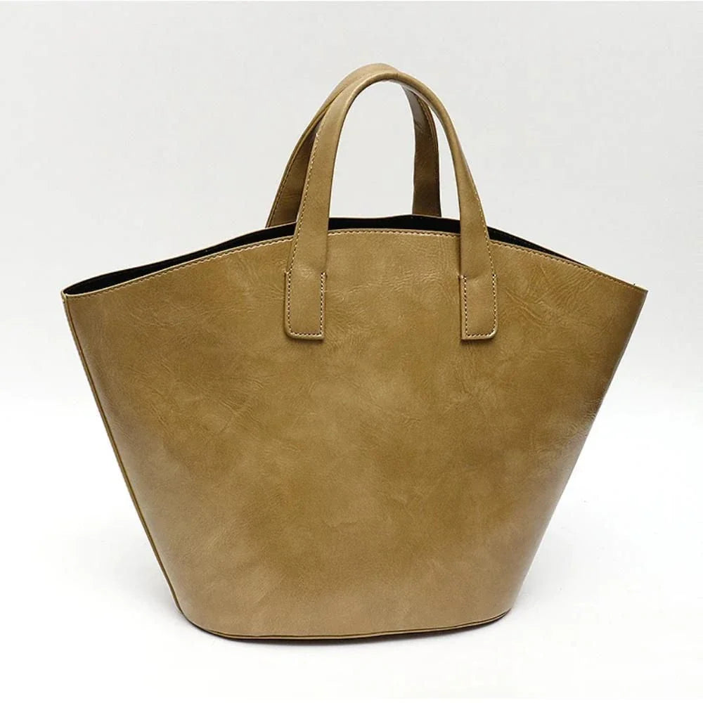 Elegant vegan leather tote bag with a unique bucket shape, versatile carrying options, and a secure zip liner for all your daily essentials.