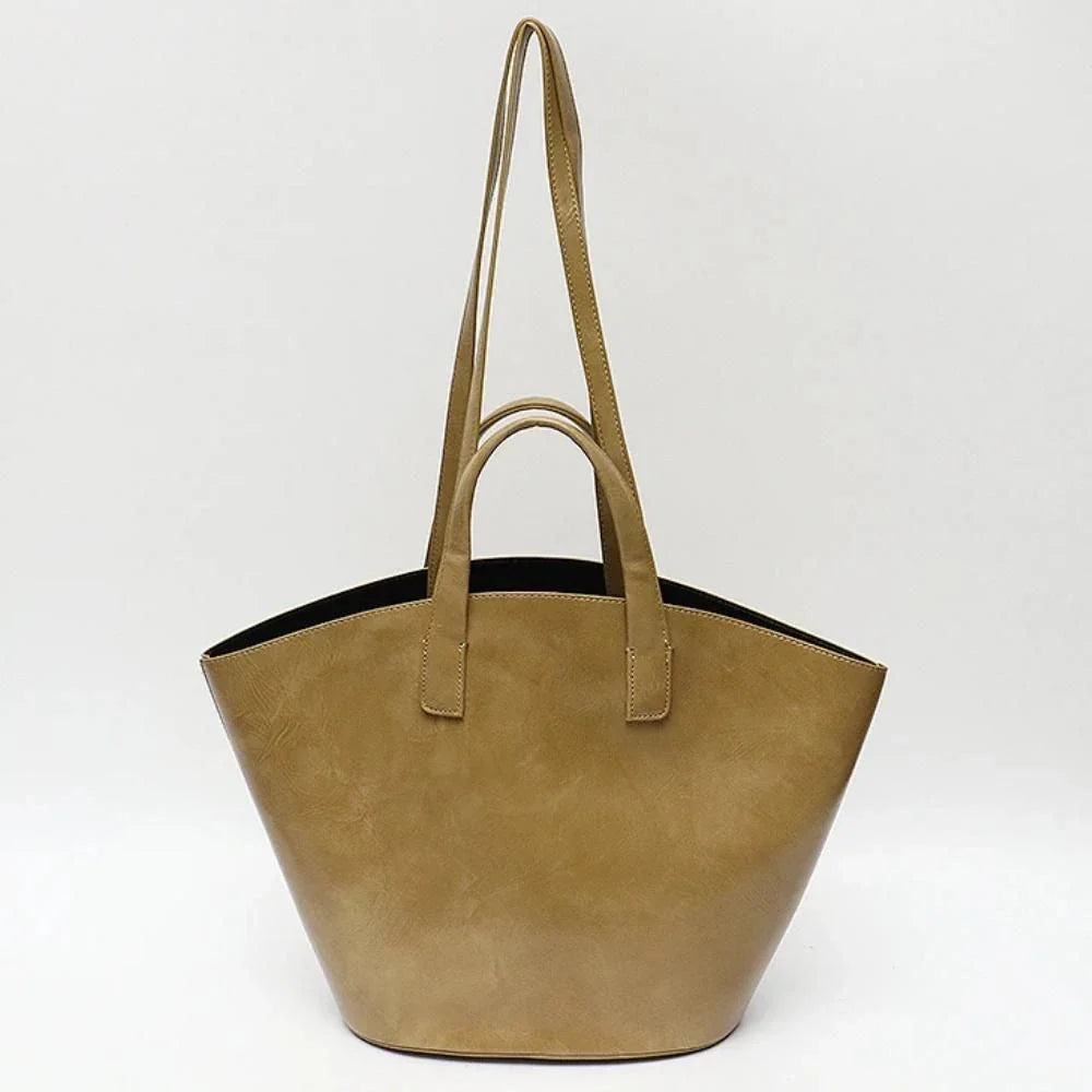Elegant vegan leather tote bag with a unique bucket shape, versatile carrying options, and a secure zip liner for all your daily essentials.