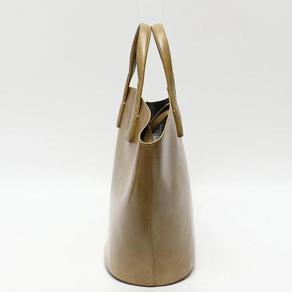 Elegant vegan leather tote bag with a unique bucket shape, versatile carrying options, and a secure zip liner for all your daily essentials.