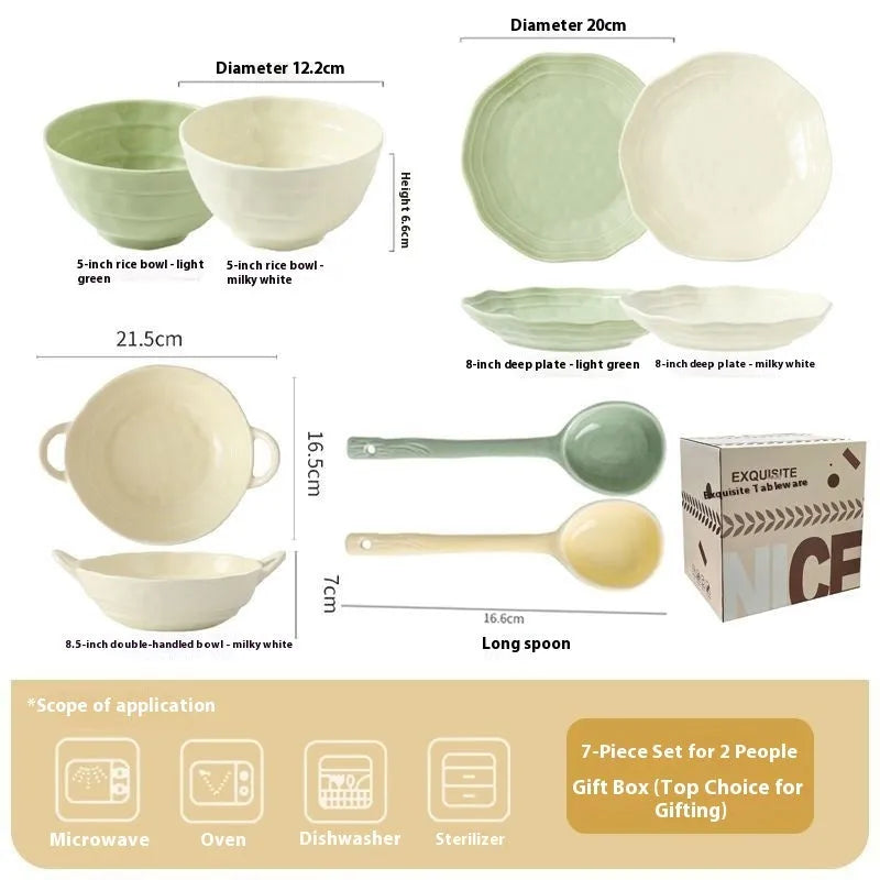 Boxed set of seven solid-colour ceramic plates and bowls on a table.