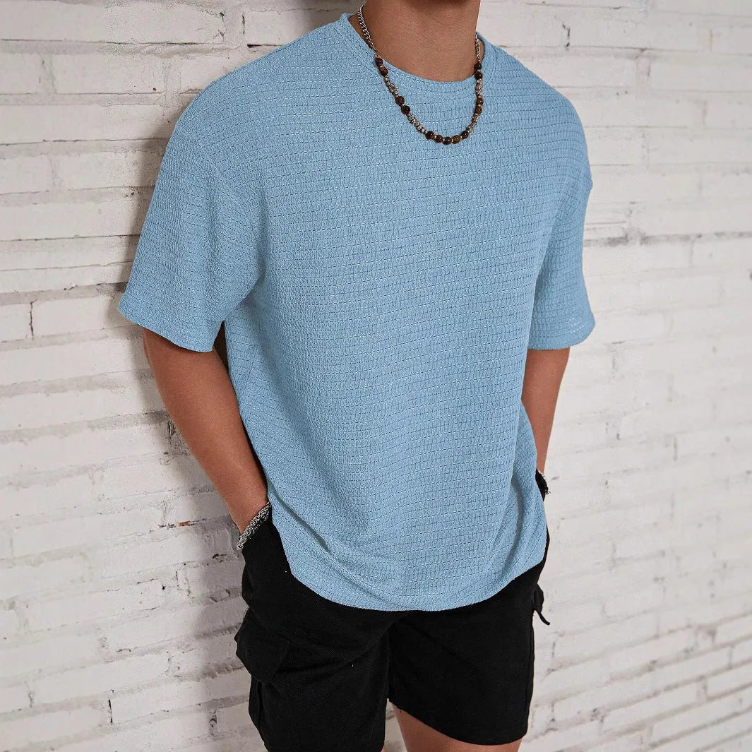Men's slim-fit solid colour short sleeve T-shirt on a hanger, showing lightweight fabric.