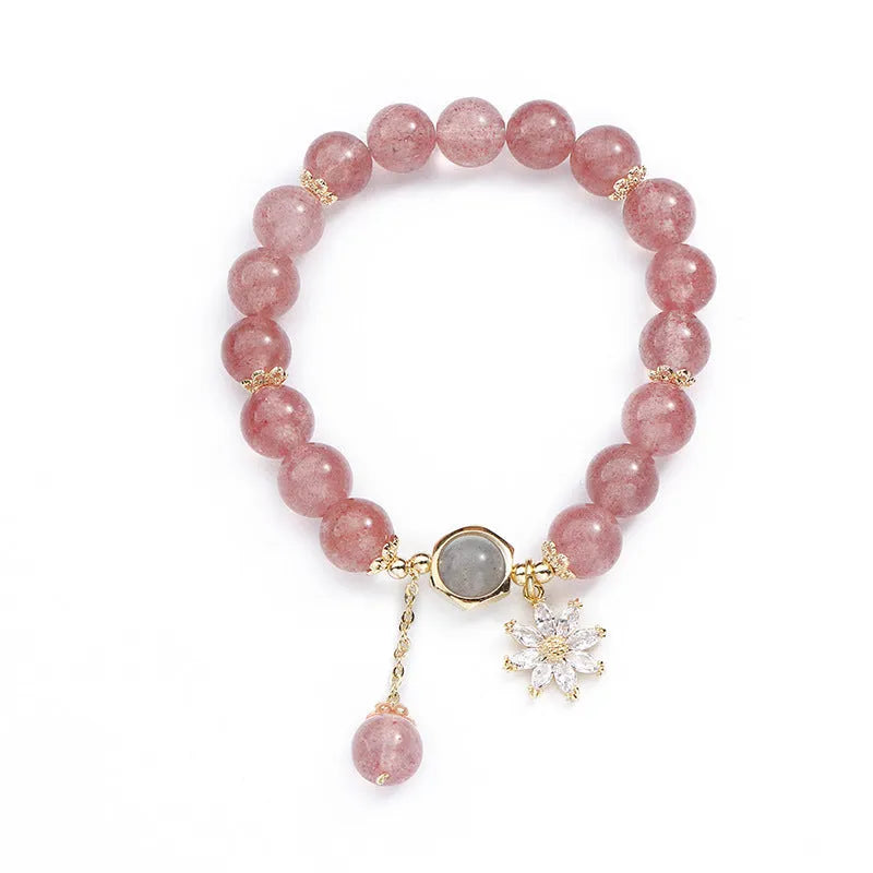 A Mori style crystal bracelet made with natural pink strawberry quartz stones and delicate electroplated floral charms.