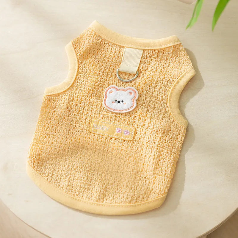 Green knitted cat clothing with a cartoon bear patch, showing hollowed-out breathable design.