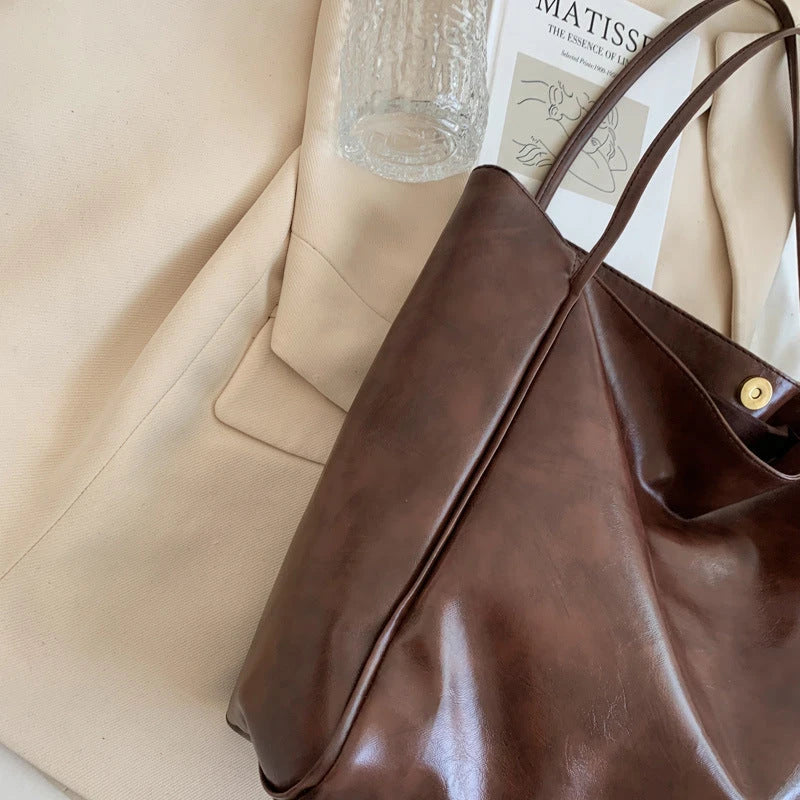 Stylish leather shoulder bag in various colors, including wine red, blue, black, brown, and beige. Showcases a versatile and spacious design for everyday use.