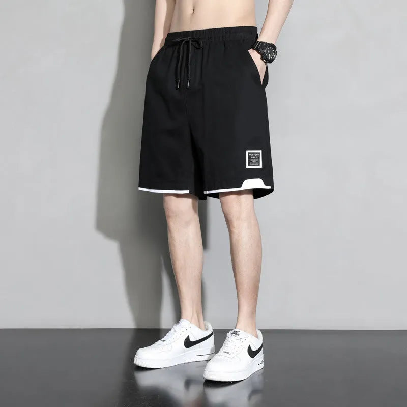 Cotton shorts for teenage boys in black, shown on a hanger, featuring a mid-waist design.