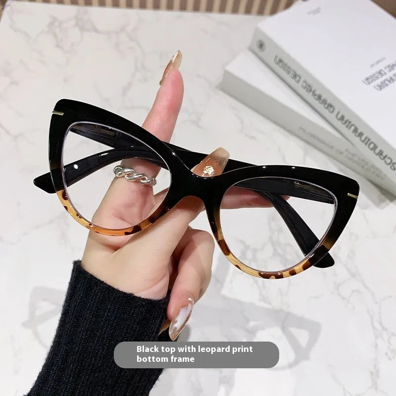 Women's black cat's eye reading glasses with gold dragon and phoenix decorations on the temples.