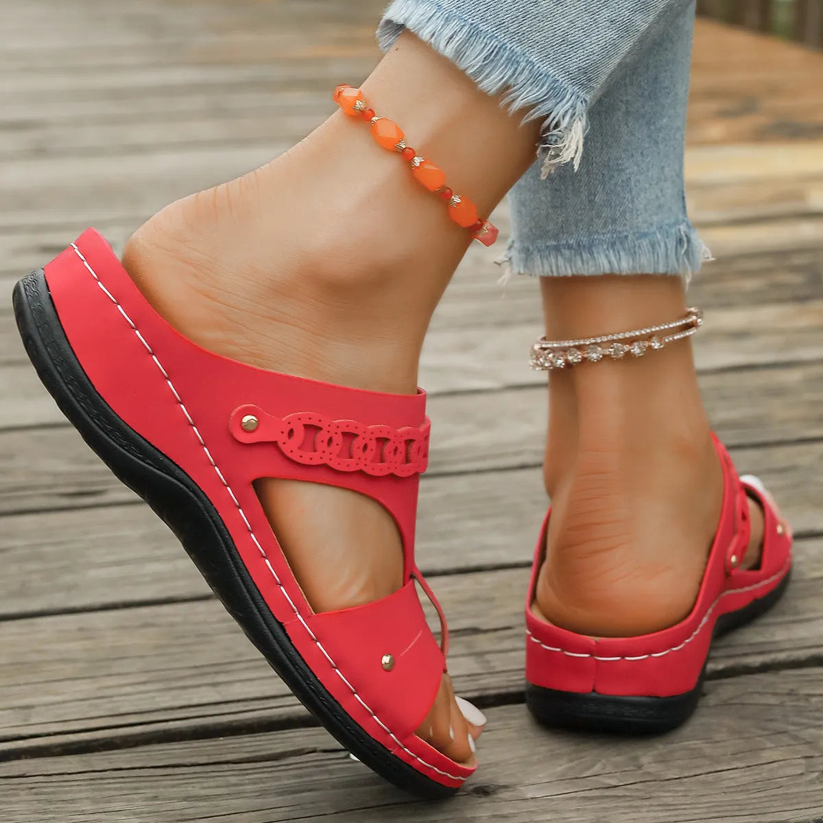 Blue roman style slippers with a slope heel and fish mouth toe holder on a wooden floor.