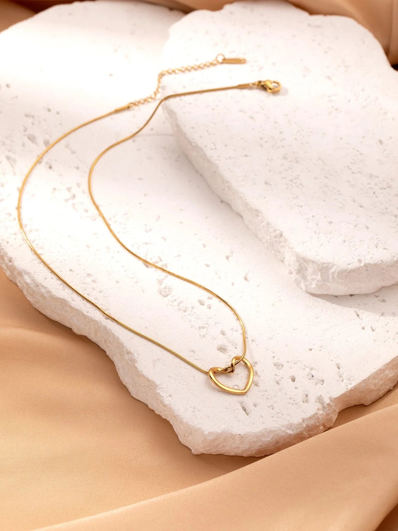 Stylish titanium steel heart pendant necklace with unique twist design, available in gold and silver colors