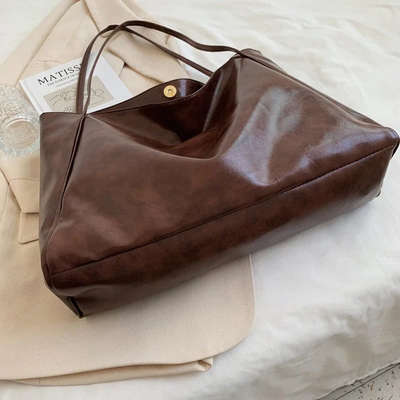 Stylish leather shoulder bag in various colors, including wine red, blue, black, brown, and beige. Showcases a versatile and spacious design for everyday use.