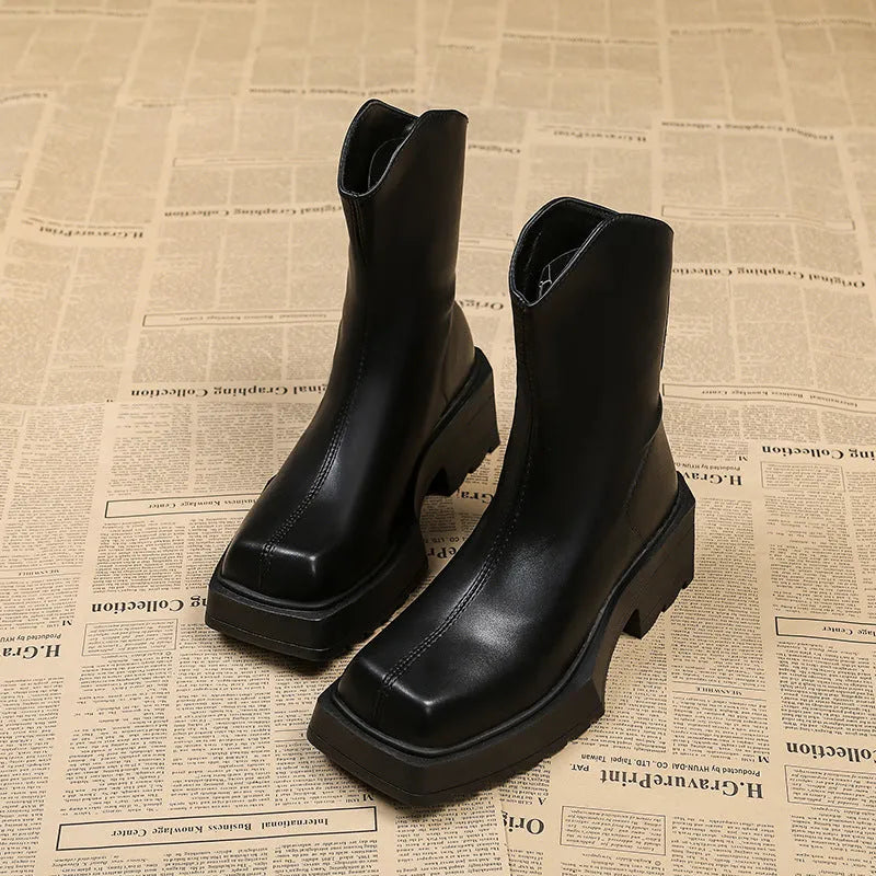 Women's black platform Martin ankle boots with square toe and back zip on a white background.