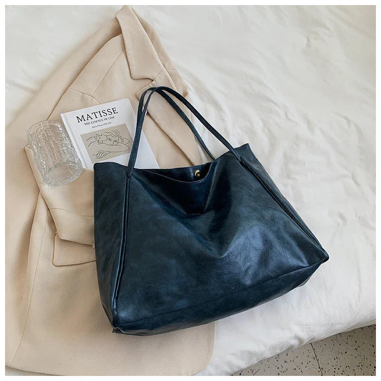 Stylish leather shoulder bag in various colors, including wine red, blue, black, brown, and beige. Showcases a versatile and spacious design for everyday use.