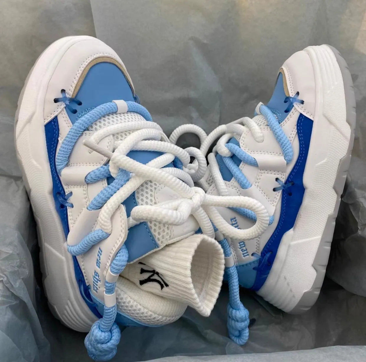 Women's grey chunky platform sneakers with white thick rubber sole and lace-up front.