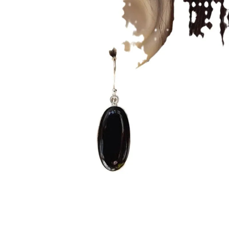 Women's geometric earrings with a black oval agate pendant in a silver electroplated frame.
