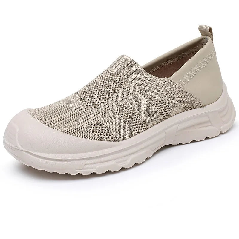 Women's one pedal slip-on shoe in black with cloth upper and PVC sole, showing round toe and flat heel design.