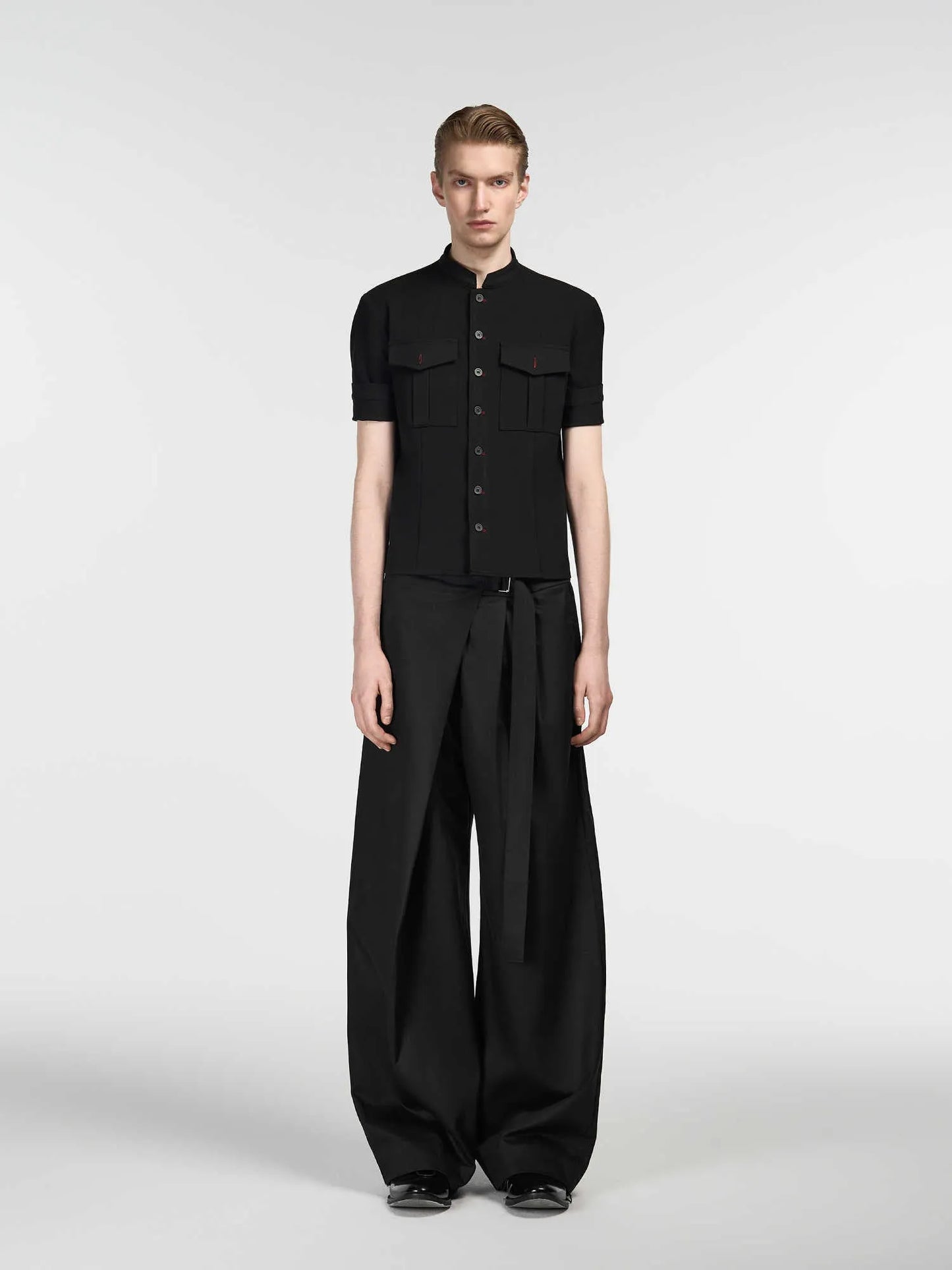 Black straight-leg trousers with a single front pleat and adjustable mid-waist on a hanger.