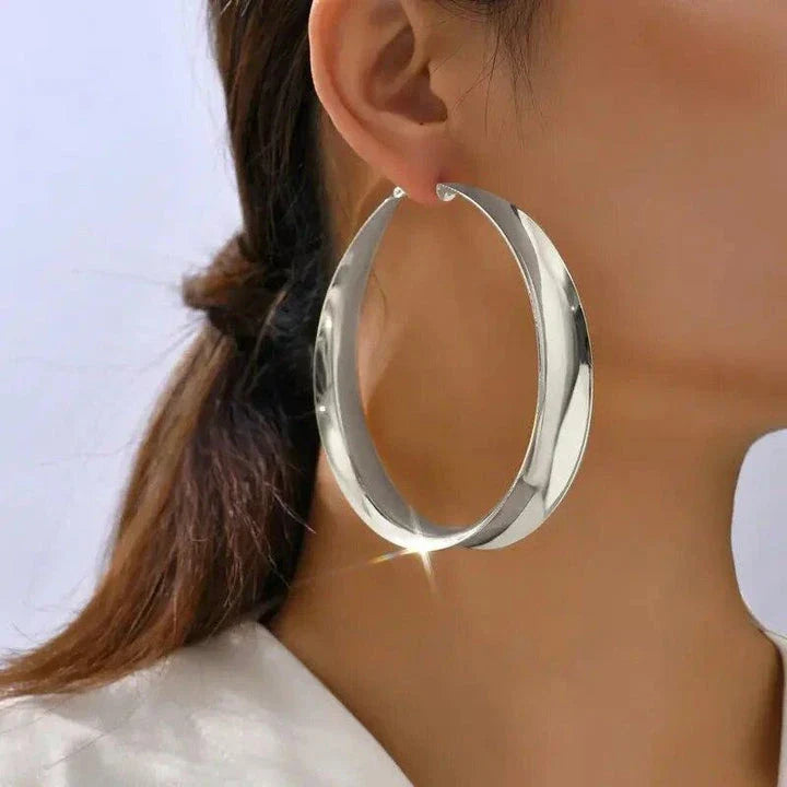 Glossy geometric metal hoop earrings in a silver finish, a trendy and versatile fashion accessory