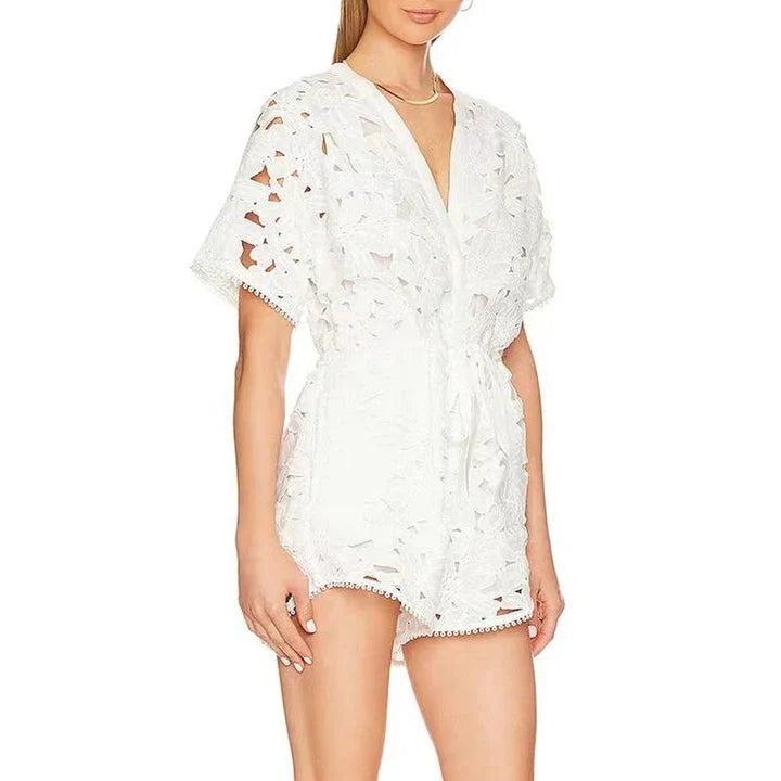 Chic embroidered hollow-out summer playsuit with a V-neck, high waistline, and short sleeves for a stylish and comfortable vacation or casual look.