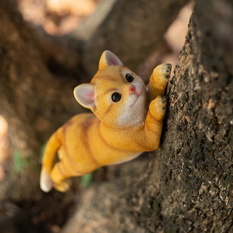 Charming resin cat statue with lifelike details, climbing on a tree branch and adding whimsical flair to any garden or indoor space.
