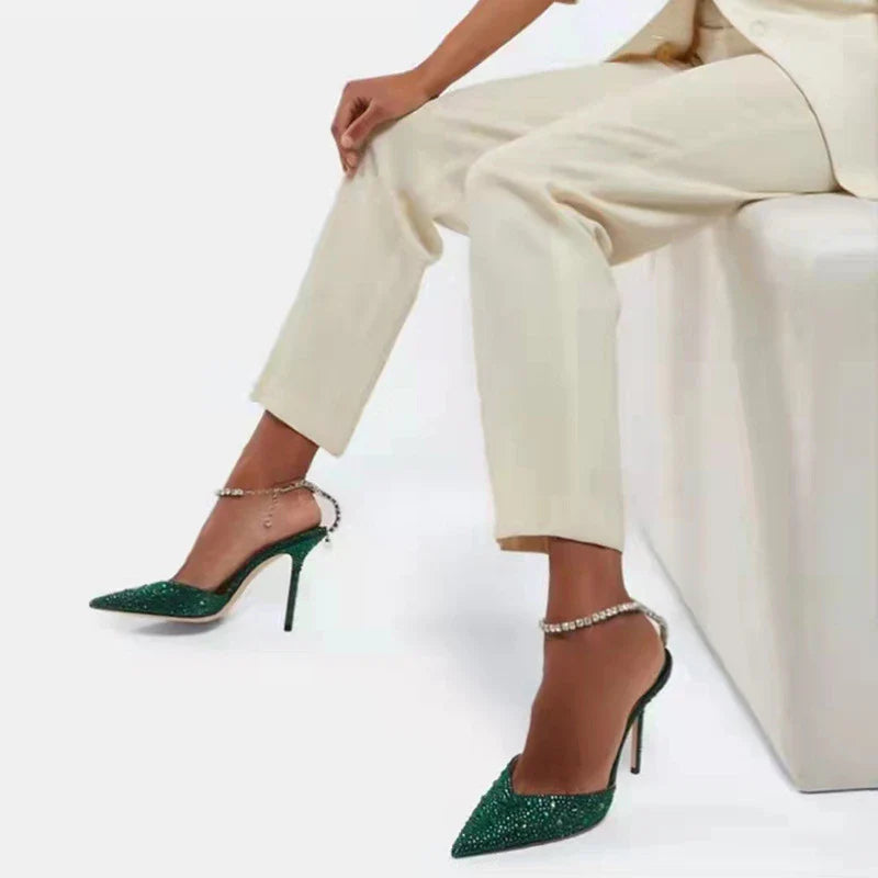 Glamorous rhinestone-embellished stiletto sandals in black and green colors, featuring a pointed toe and sleek silhouette