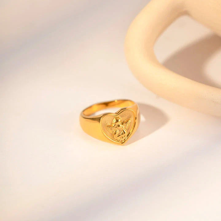 Sophisticated gold-plated stainless steel ring with a geometric heart and angel design, perfect for adding a touch of elegance to any outfit.