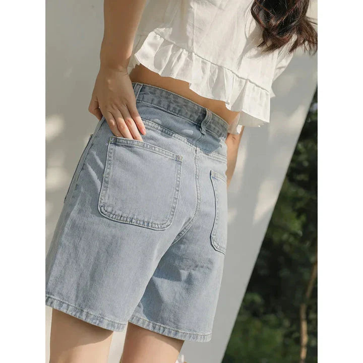 Light blue denim shorts with delicate floral embroidery, providing a stylish and comfortable summer look for women.