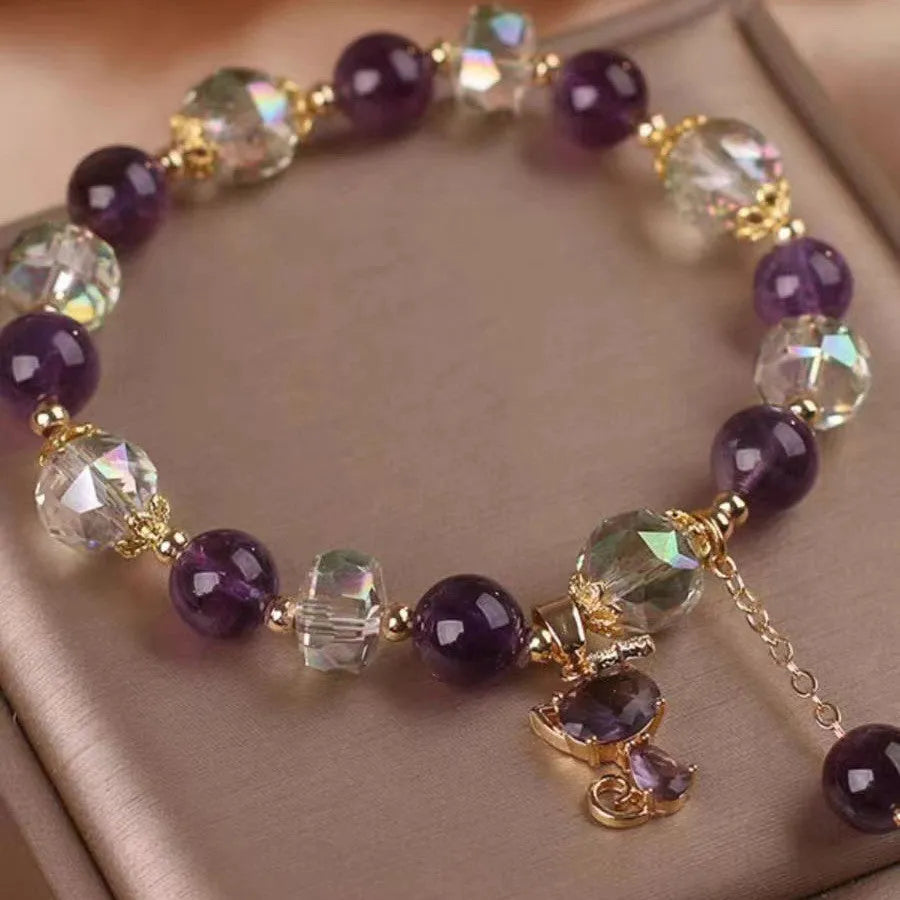Natural purple amethyst crystal bracelet with nine-tailed fox and flower pendants on wrist.