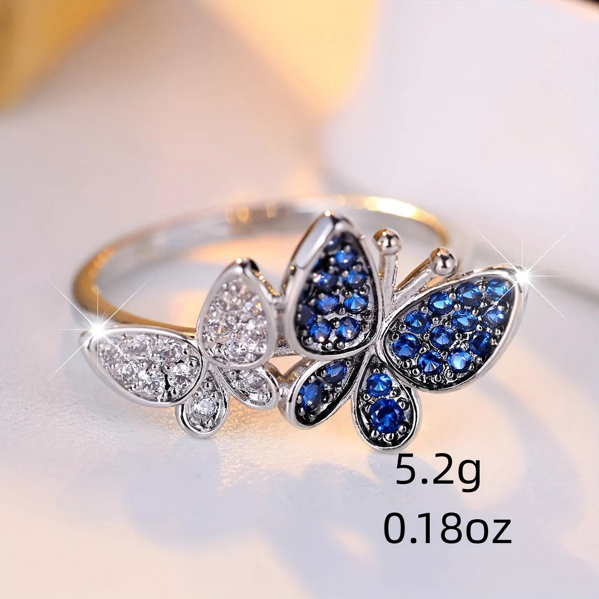 Silver-tone blue and white butterfly design ring for women on a white background.