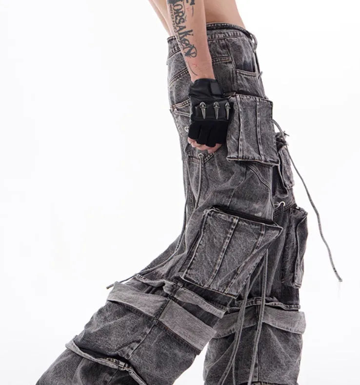Grey distressed denim overalls with rope stitching on a man, showcasing the mop pant style.