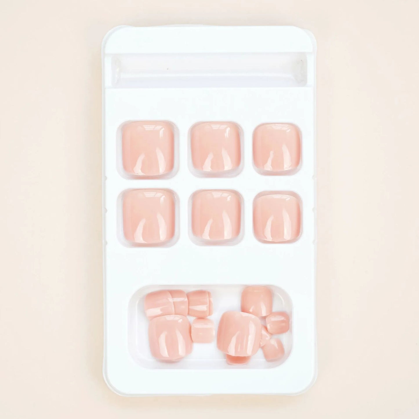 Fashion Personality toe nail stickers in skin colour with design, next to tube of adhesive glue on a flat surface.