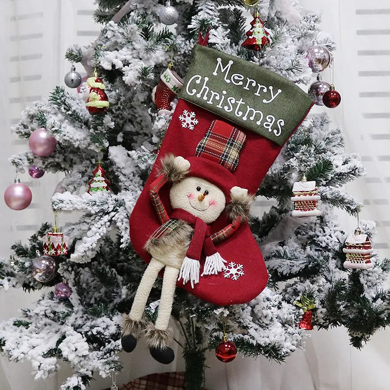 Set of three large red, white, and brown Christmas stockings with 3D Santa, Snowman, and Reindeer designs hanging on a tree.