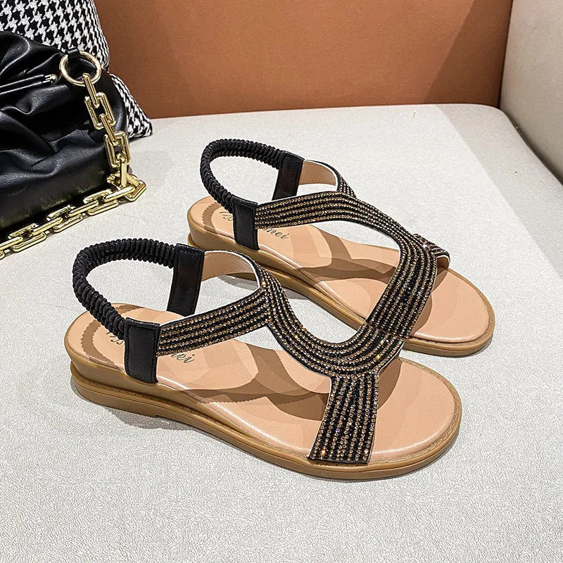 Gold patent leather women's sandals with rhinestone decoration on the strap.