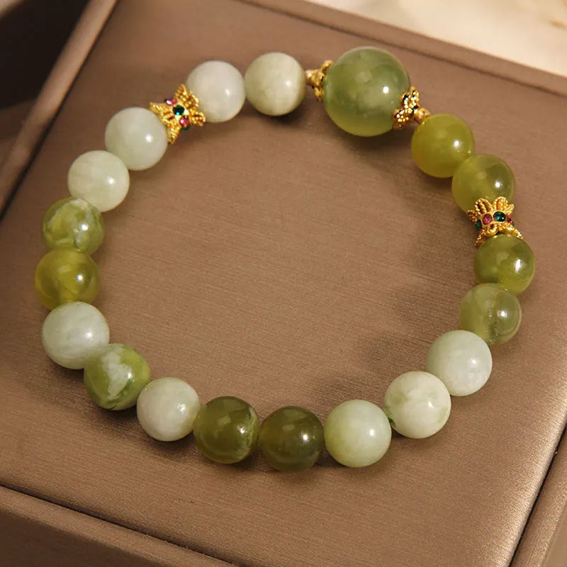 Original design women's bracelet with a green Xiuyan jade stone on wrist.