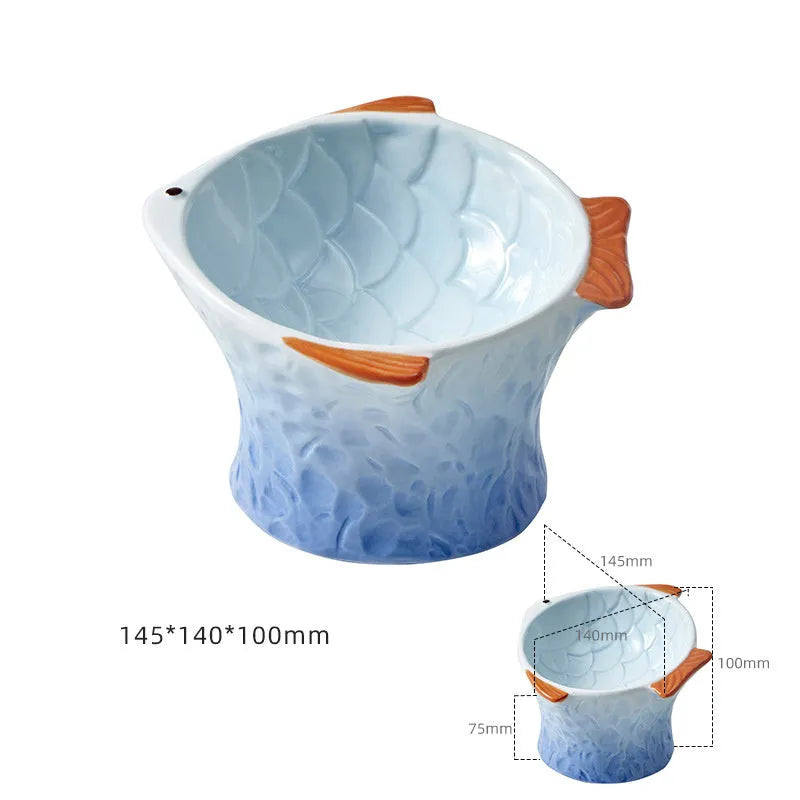Set of four blue fish-shaped ceramic cat bowls with tilted design on a wooden table