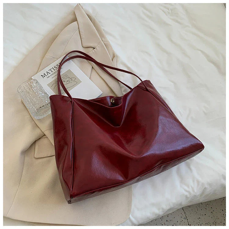 Stylish leather shoulder bag in various colors, including wine red, blue, black, brown, and beige. Showcases a versatile and spacious design for everyday use.