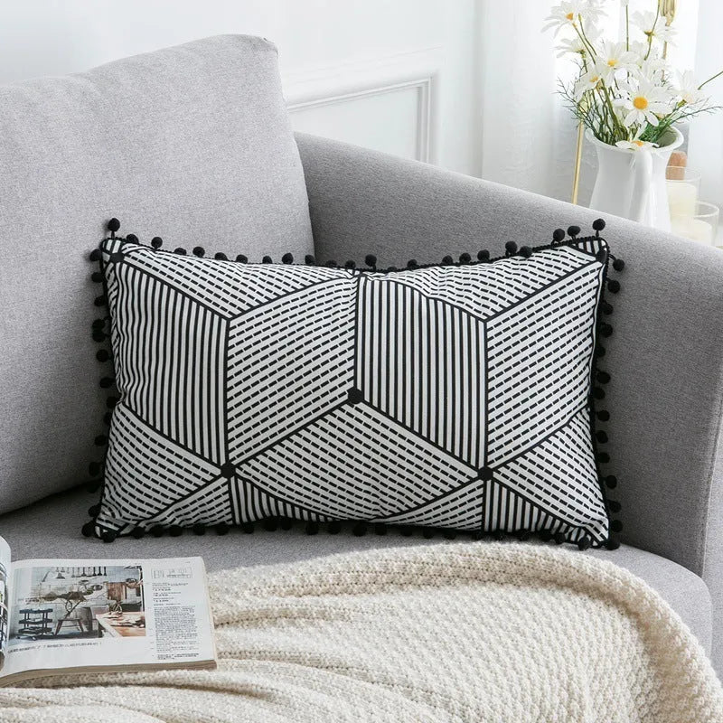 Bohemian style decorative pillowcase in light grey colour on a sofa.