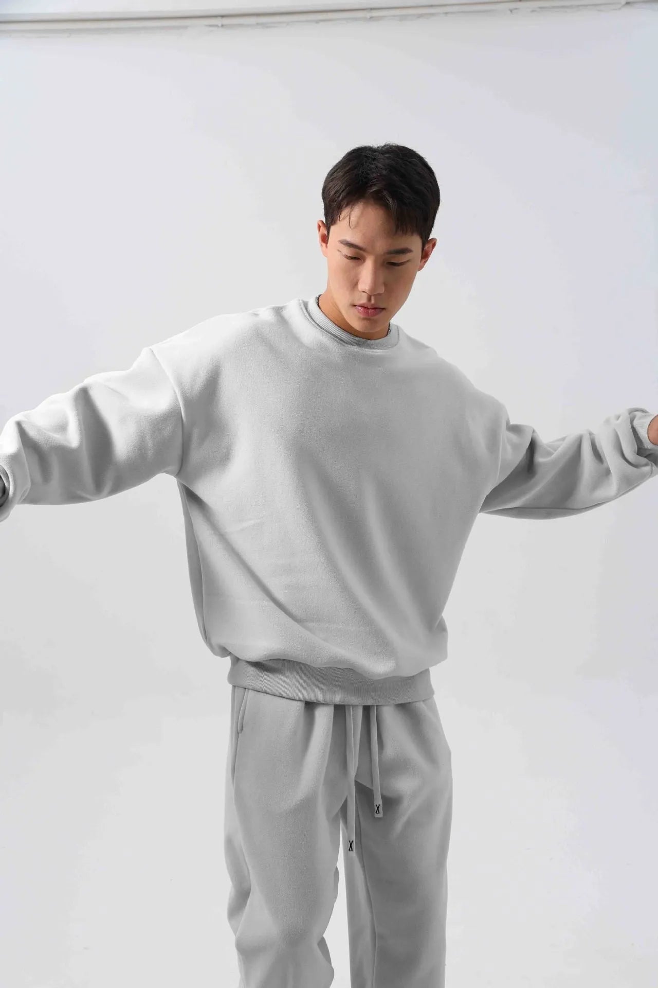 Man wearing a two-piece army green polar fleece suit with crew neck top and padded trousers.